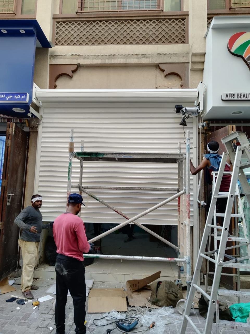 Technicians working on a white rolling shutter
